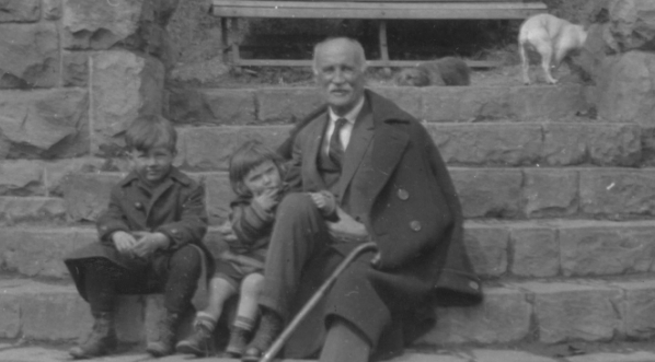  Julian Fałat z wnukami siedzą na schodach obok kapliczki w ogrodzie willi w 1928 roku.  