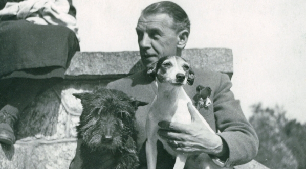  Juliusz Osterwa siedzący na schodach z psami.  