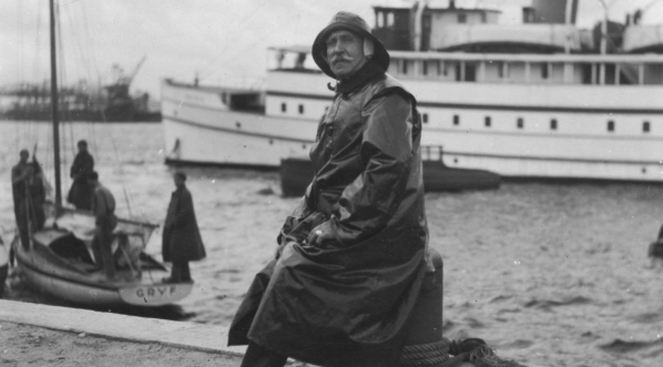  Marian Zaruski - kapitan harcerskiego szkunera "Zawisza Czarny" na nabrzeżu portu ubrany w sztormiak.  