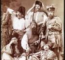 Grupa osób w kostiumach historycznych tworząca "żywy obraz" wg "Ogniem i  mieczem" Henryka Sienkiewicza.
