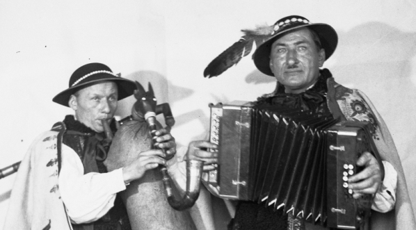  Dudziarz Wincenty Pyrdoł w towarzystwie harmonisty i mistrza gry na listku bluszczowym Michała Piksy (z prawej) podczas gry.  